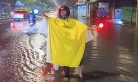 Người đàn ông ở TP.HCM bì bõm trong đêm hướng dẫn xe tránh đường ngập