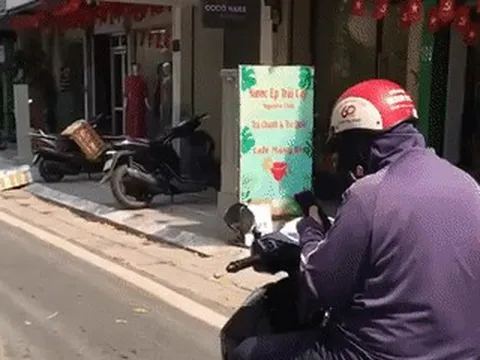 Người đi xe máy "dán mắt" vào điện thoại, thói quen nhan nhản trên đường phố