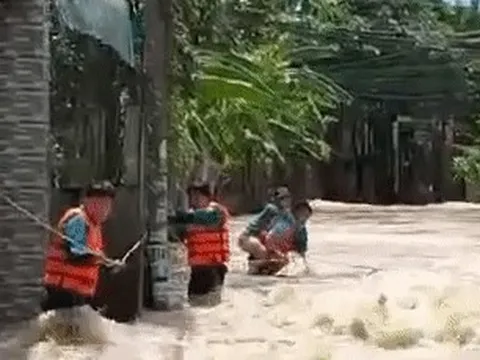 Khu dân cư bị ngập, dân quân cõng người phụ nữ qua dòng nước chảy xiết