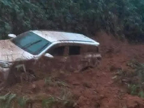 Ô tô 7 chỗ màu trắng bị đất, đá vùi lấp