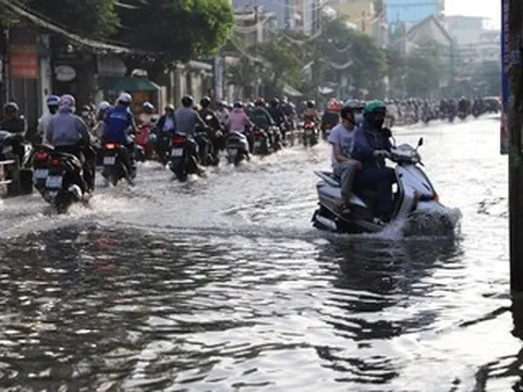 Người dân TPHCM xắn quần, co chân vượt đường ngập lênh láng vào giờ cao điểm