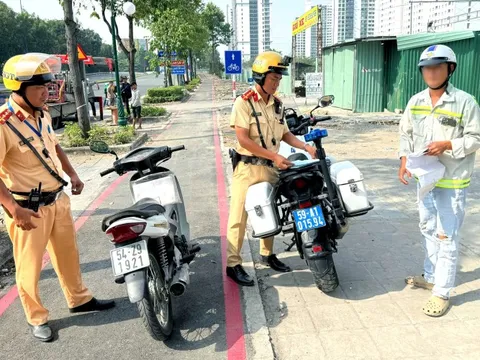 Cảnh sát giao thông xử phạt người chạy xe máy vào làn dành riêng cho xe đạp trên đường Mai Chí Thọ