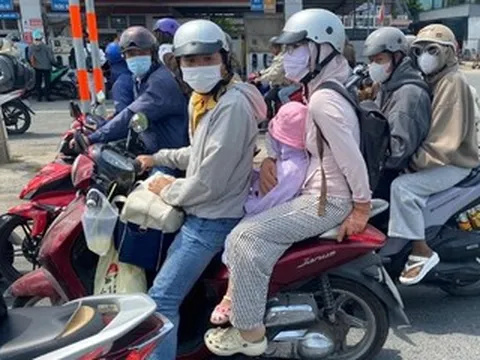 Trẻ nhỏ ngủ gục trên xe máy theo cha mẹ trở lại TPHCM sau kỳ nghỉ 30/4-1/5