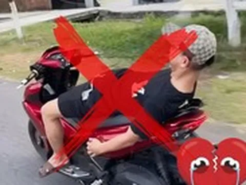 Không đội mũ bảo hiểm, buông cả 2 tay nằm dài trên yên khi lái xe máy trên đường