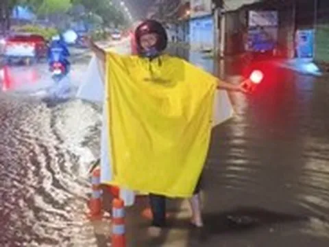 Người đàn ông ở TP.HCM bì bõm trong đêm hướng dẫn xe tránh đường ngập