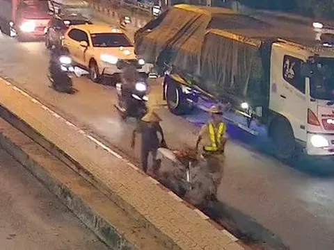 Dừng lại giữa dòng xe, cảnh sát giao thông dắt xe giúp cụ bà qua đường nhận mưa lời khen