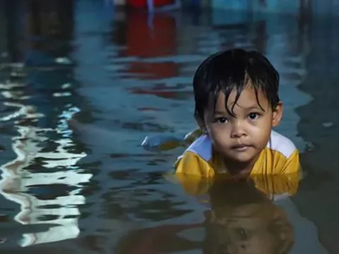 Người dân đắp ‘đê’ trước cửa nhà, trẻ em bơi giữa dòng triều cường đạt đỉnh tại TP.HCM