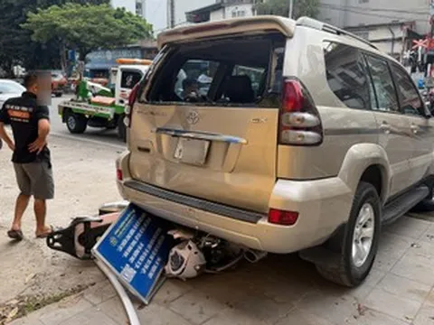 Ô tô Prado lùi trên đường Hà Nội, cuốn xe máy chở 2 phụ nữ vào gầm